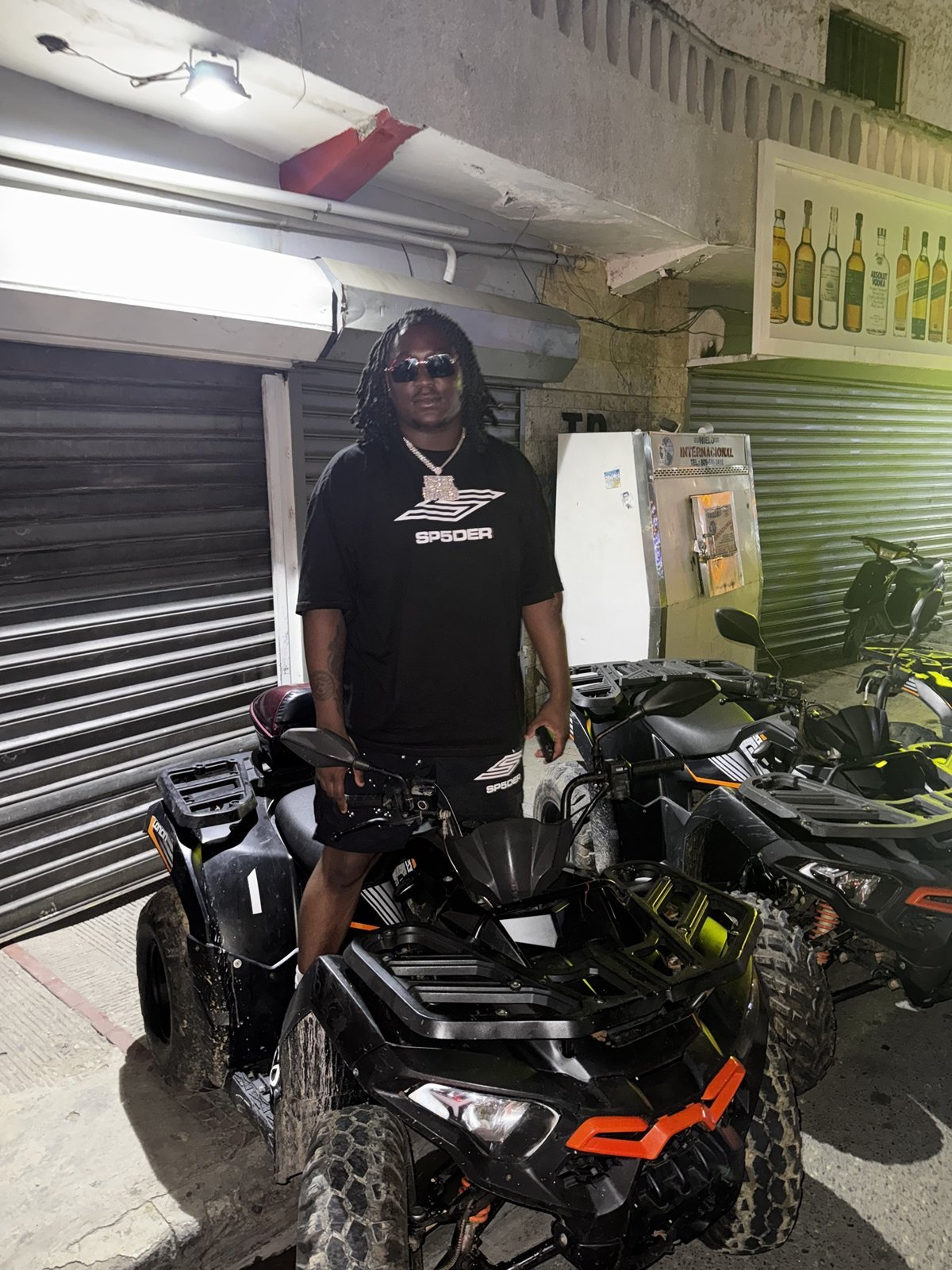 Freeband standing with a black ATV at night
